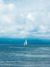 Sailboat sailing on sea against sky