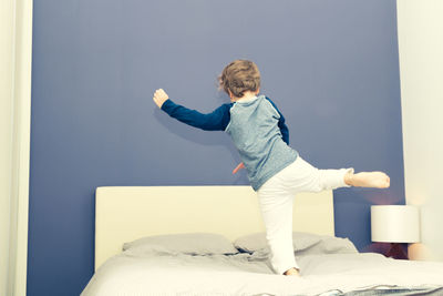 Boy playing on bed at home