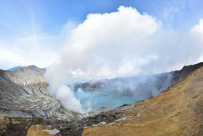 Smoke emitting from volcanic mountain against sky