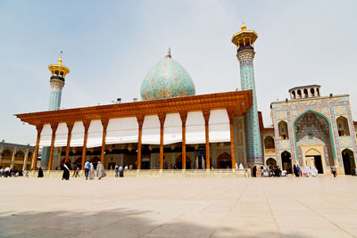 Group of people outside temple against sky