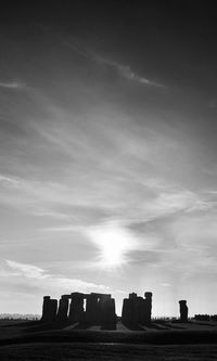 Silhouette rocks on field against sky