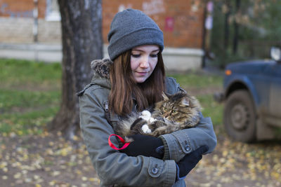 Close-up of young woman holding kitten