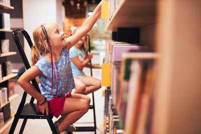 Schoolgirls looking for books in school library. elementary education. back to school