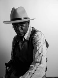 Portrait of man wearing hat against wall