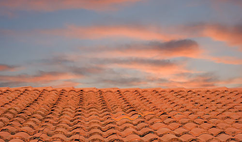 Roof of building against sky during sunset