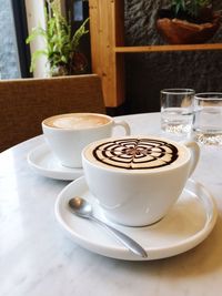 Close-up of coffee cups served on table