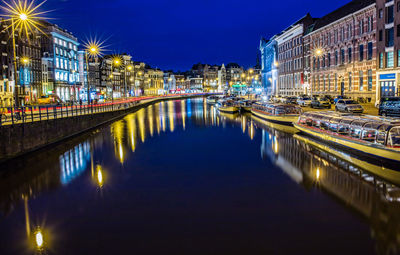 Illuminated canal amidst buildings in city at night