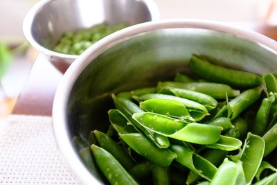 Close-up of green pea pods in container