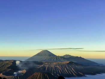 Scenic view of snowcapped mountains against clear blue sky