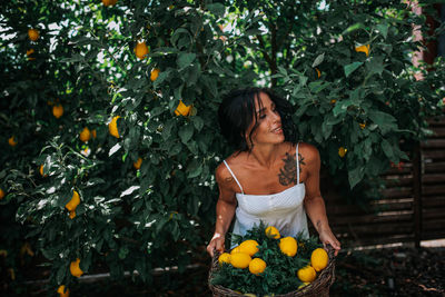 Young woman standing against plants