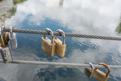 Close-up of padlocks on railing against bridge