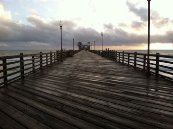 Empty pier over sea against sky