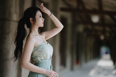 Young woman standing against wall