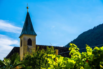 Church with bell tower among the vineyards with the blue sky at lake caldaro in bolzano italy