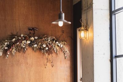 Close-up of illuminated light bulb hanging on wall