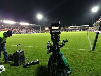 People relaxing on soccer field at night