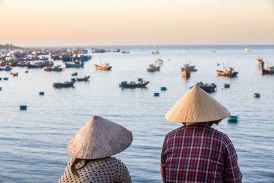 Unidentified vietnamese women overlooking fishermans bay full of fishing boats.