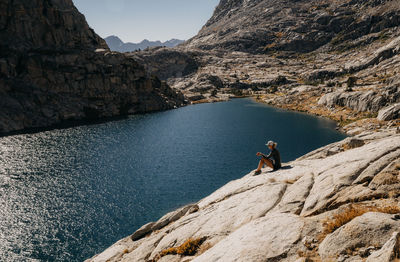 People on rock by mountain