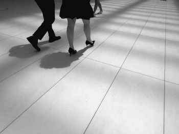 Low section of women walking on tiled floor