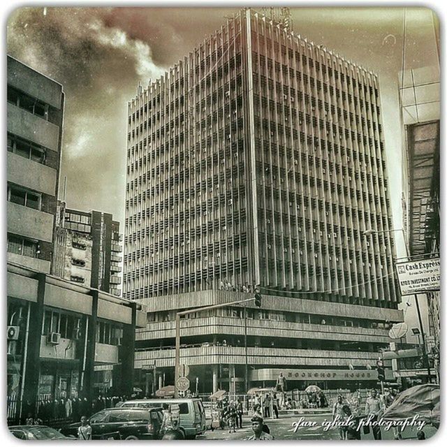 transfer print, architecture, building exterior, auto post production filter, built structure, sky, city, transportation, cloud - sky, land vehicle, building, car, low angle view, modern, street, mode of transport, city life, cloudy, cloud, road