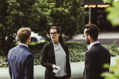 Male and female entrepreneurs discussing business strategy while standing outdoors