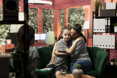 Side view of friends using mobile phone at restaurant