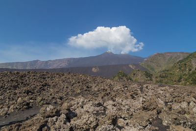 Panoramic view of arid landscape against blue sky