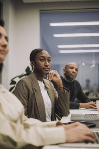 Businesswoman with male and female colleagues working overtime at workplace