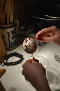 Cropped hand of woman preparing easter egg