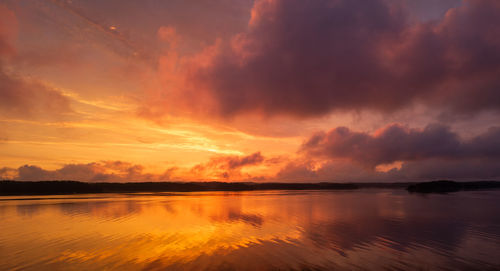 Scenic view of sea against dramatic sky at sunset