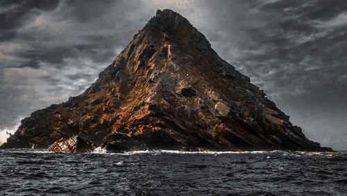 Scenic view of rock formation in sea against sky