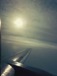 Close-up of airplane flying over sea against sky