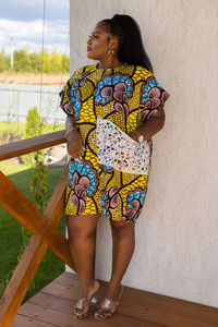 Young woman standing against wall