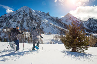 People on snowcapped mountain against sky