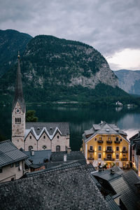 Buildings by mountains against sky