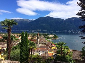 Scenic view of town by mountains against sky