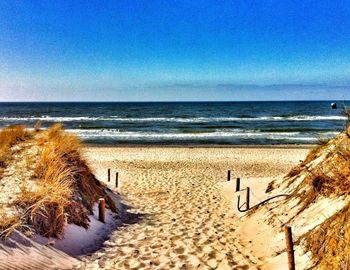 Scenic view of beach against clear blue sky