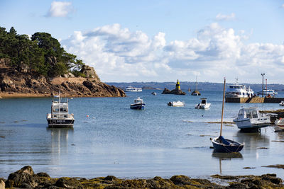 Sailboats moored on sea against sky