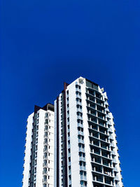 Low angle view of modern building against clear blue sky