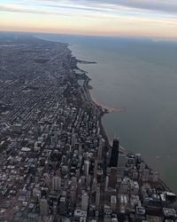 High angle view of buildings by sea against sky