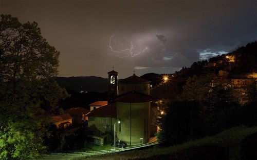 Illuminated houses against sky at night