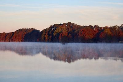 Scenic view of lake by trees against sky during autumn