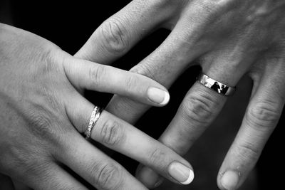 Cropped hands of bride and groom showing wedding rings