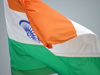 Low angle view of flag standing against white wall