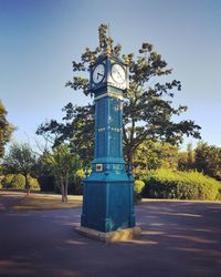Statue by road against clear blue sky