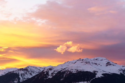 Scenic view of snowcapped mountains against sky during sunset