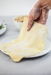 Cropped hand of woman holding dough in plate