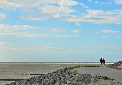 People on beach against sky
