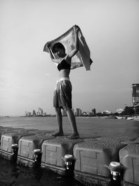 Boy standing on beach against clear sky