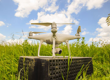 Close-up of airplane on field against sky